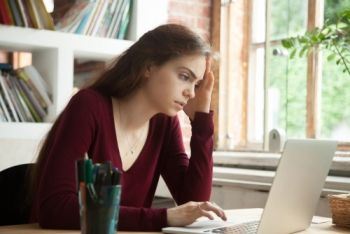 Concerned Girl Working on a Laptop